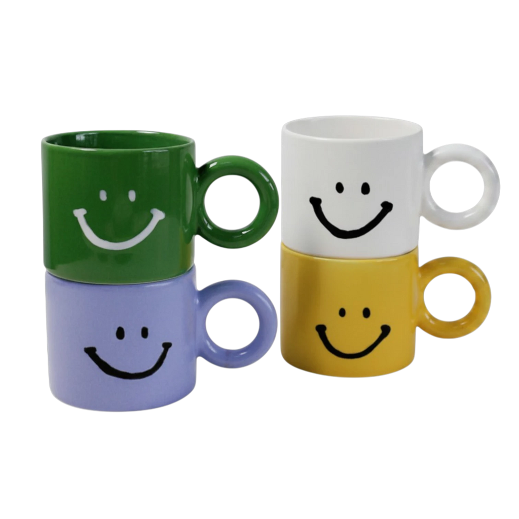 HOMELIVY set of four ceramic mugs in green, white, light blue, and yellow, each featuring a black or white smiley face