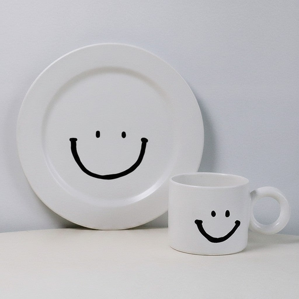 HOMELIVY white ceramic breakfast set featuring a plate and mug with a minimalist black smiley face design.