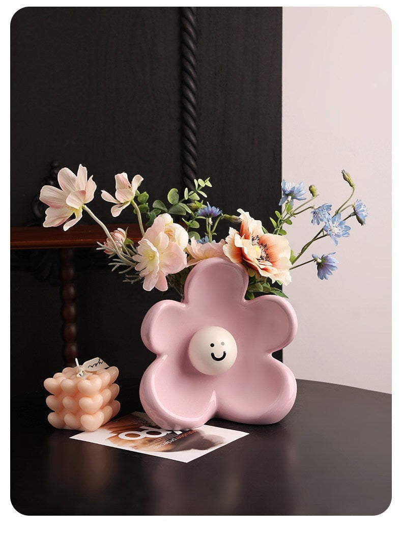 HOMELIVY pink ceramic flower-shaped vase with a white smiley face center, holding a bouquet of pastel flowers.
