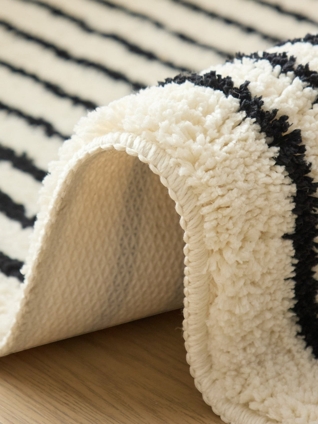 HOMELIVY minimalist striped bath mat rug in cream and black, made of soft, plush material.