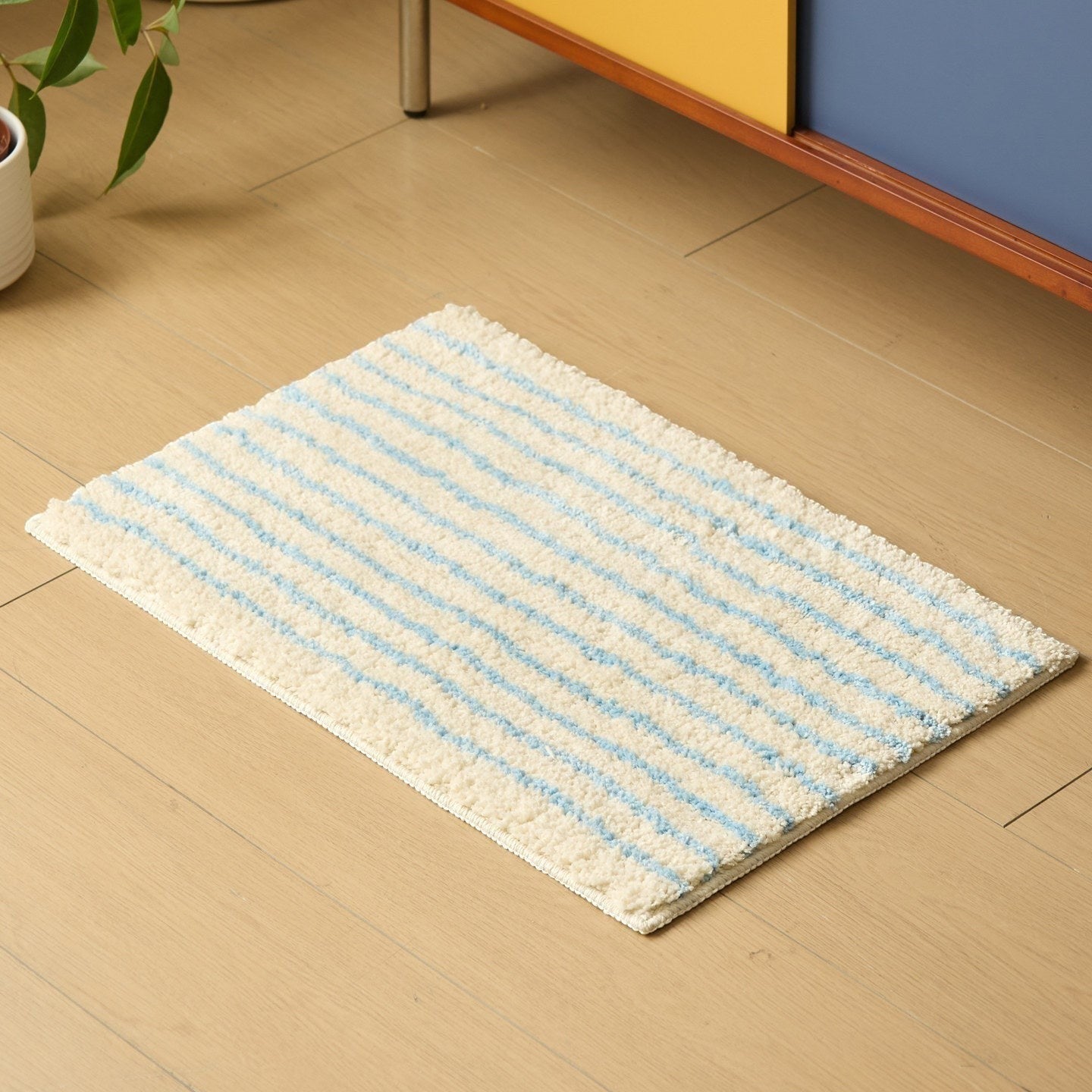 HOMELIVY minimalist striped bath mat rug in cream with light blue stripes. Soft texture, rectangular shape.