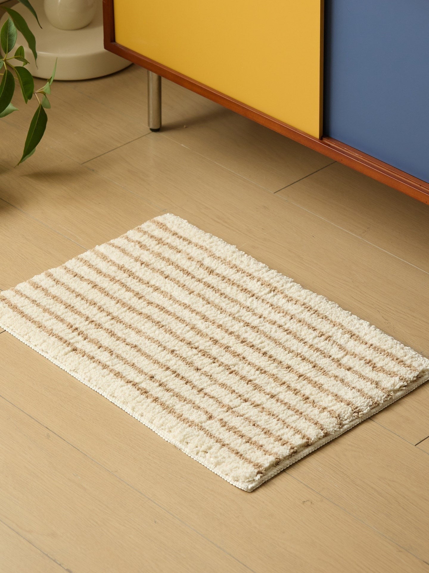HOMELIVY minimalist striped bath mat rug in cream with brown stripes, made of soft, absorbent material.