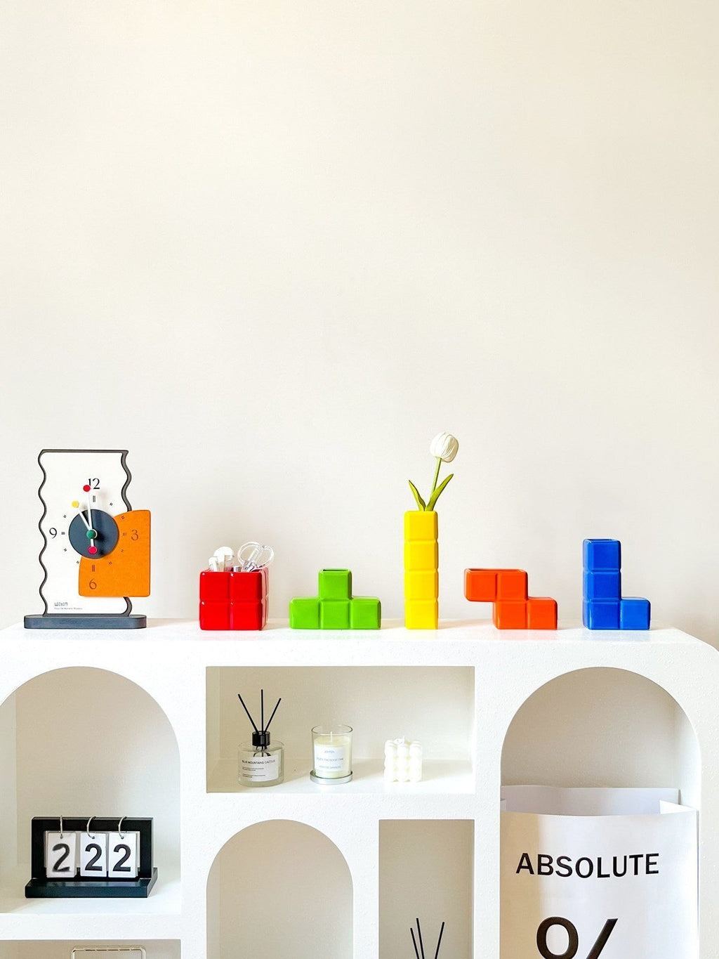 HOMELIVY Tetris decorative ceramic vases in vibrant primary colors displayed on a modern white arched shelf.