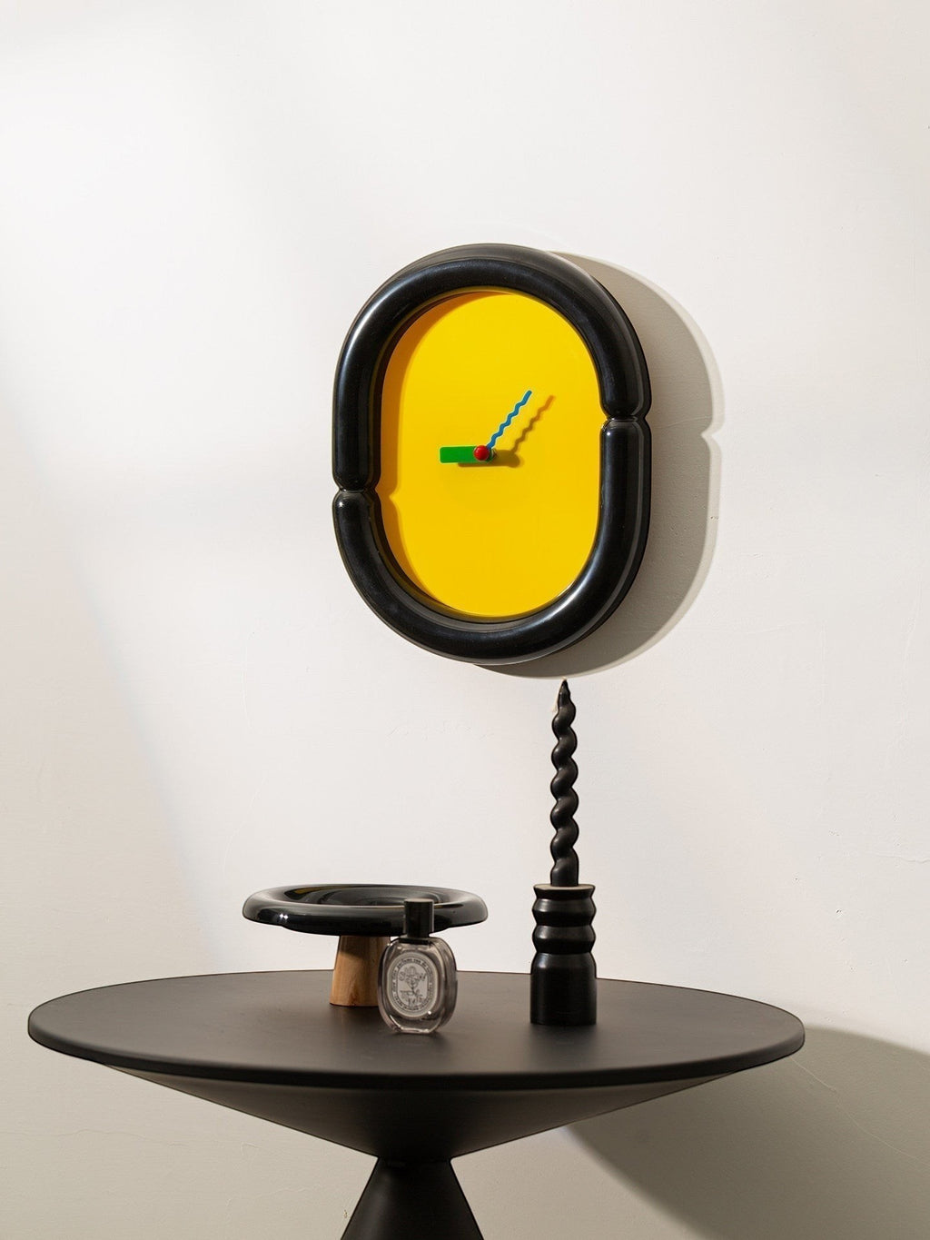 HOMELIVY yellow wall clock with black sculptural frame and multicolored hands, a statement piece for eclectic decor.