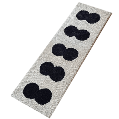 Minimal runner rug off white plush texture with five black mickey mouse head silhouettes in a diagonal line
