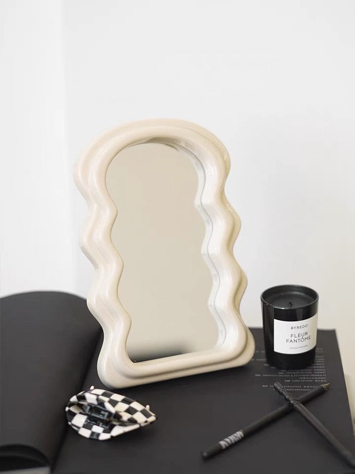 Cream-colored table squiggly mirror with wavy edges and a smooth matte finish perfect for decorative use