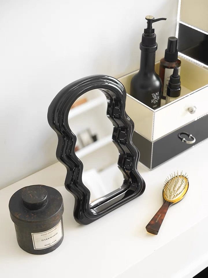 Black glossy ceramic table squiggly mirror with wavy sculpted frame for decorative wall display
