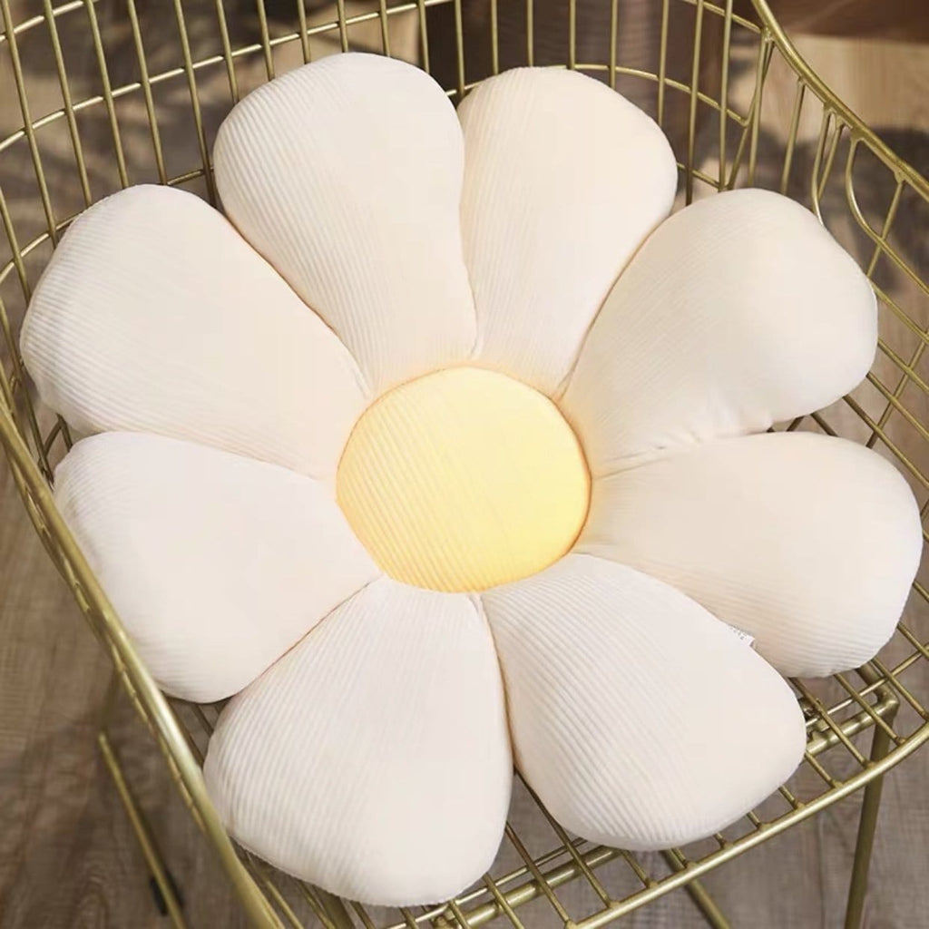 A pastel flower cushion shaped like a white plush daisy with soft yellow ribbed fabric center