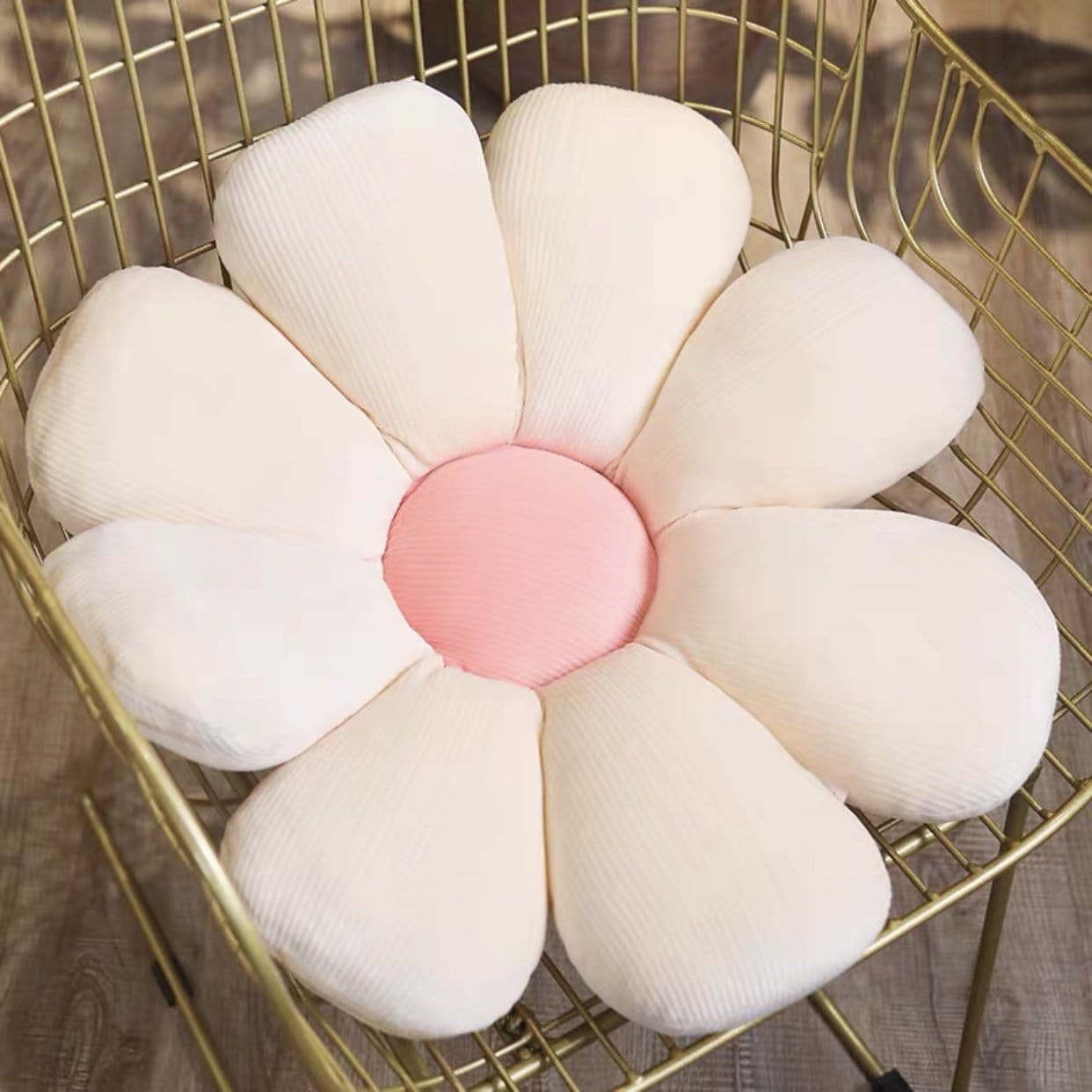 A plush pastel flower cushion with a soft pink center made from ribbed white fabric for decorative use