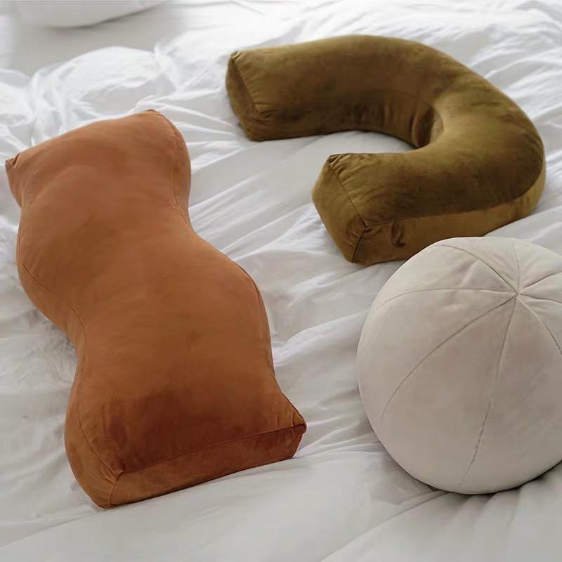 A caramel-colored velvet shaped plush cushion featuring a soft cushioned body-shaped pillow design
