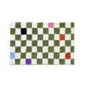 A plush rectangular green color tiles checkered rug with alternating green and white squares and colorful patches