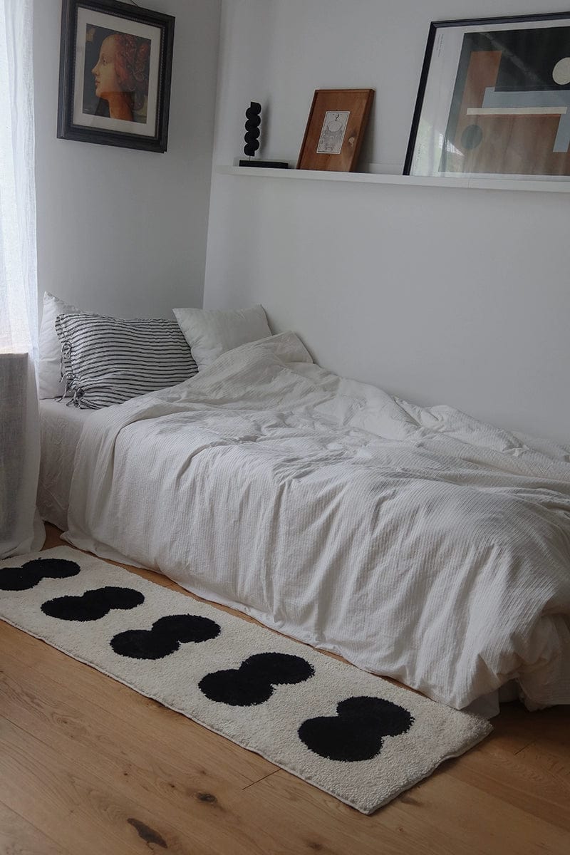 Minimal runner rug in cream with bold black cloud-like shapes arranged in a row for a modern look