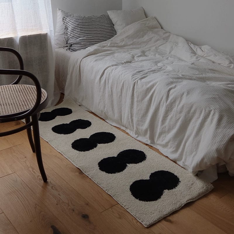 Minimal runner rug cream-colored plush runner rug with bold black rounded oval shapes arranged in a row