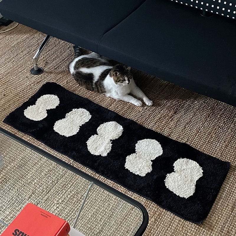 Minimal runner rug in black with white fluffy cloud-like shapes made of soft material for stylish floor decor
