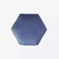 A plush velvet geometry pillow in navy blue with a hexagonal shape and cushioned soft sides and rounded top